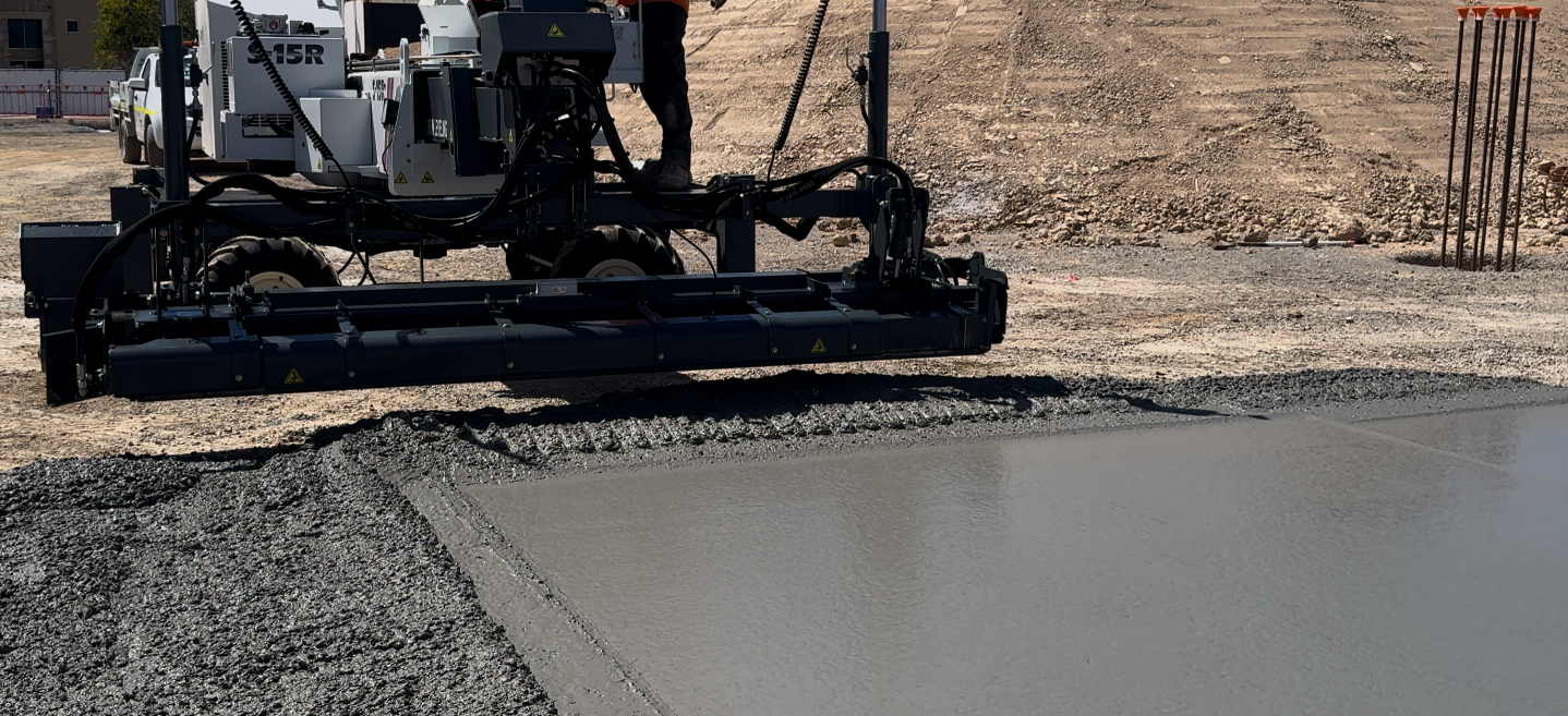A man standing on a machine, overseeing customised concreting work in progress.