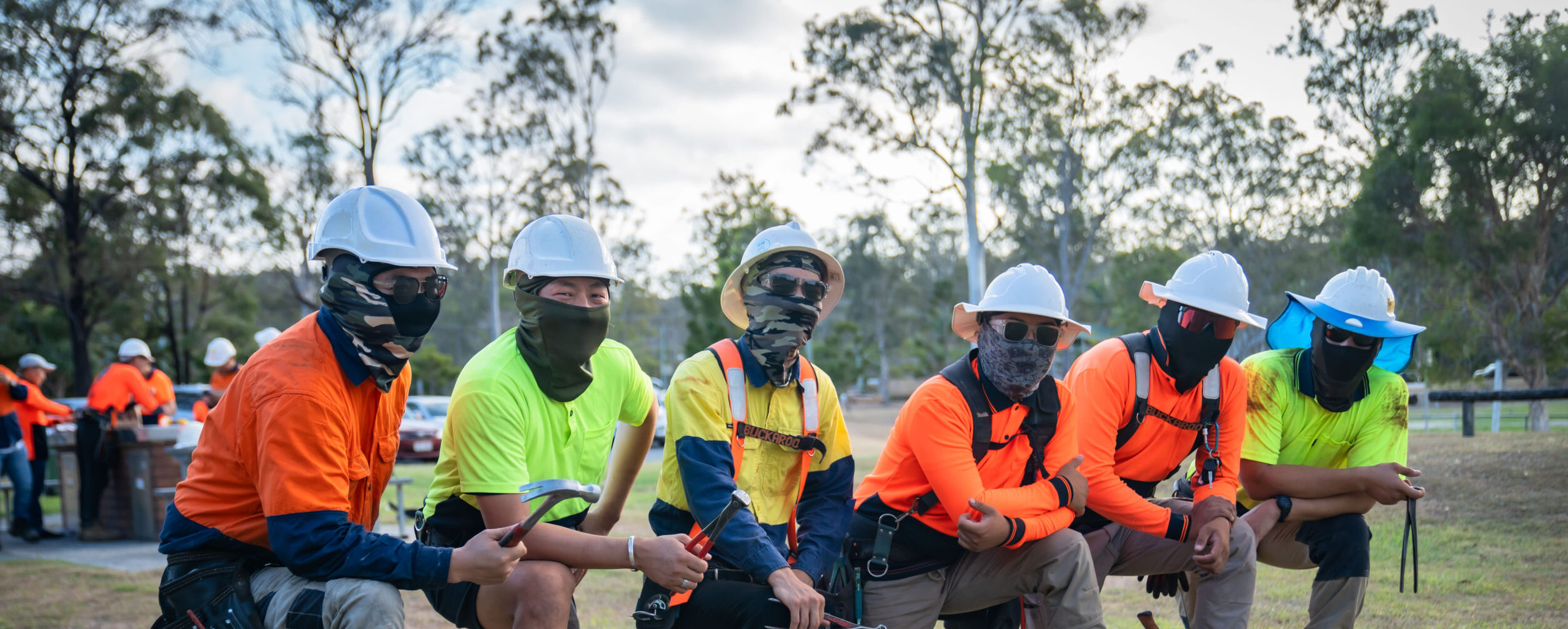 A group of people wearing helmets and masks stands near durable structures.